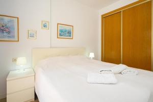 a bedroom with a white bed with towels on it at Alborada Golf 3 1A Spaniahome in Albir +16 photos