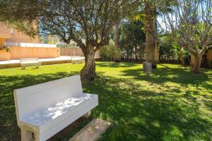 a white bench sitting in a park with trees at Alborada Golf 3 1A Spaniahome in Albir