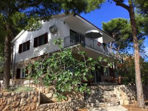 a white house on top of a stone wall at Apartmani Diego in Sveta Nedelja