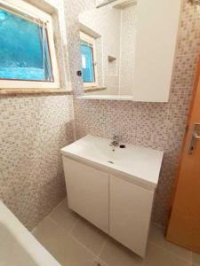 a bathroom with a white sink and a mirror at Apartmani Diego in Sveta Nedelja