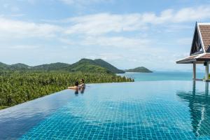 a couple sitting in the infinity pool of a resort at InterContinental Koh Samui Resort, an IHG Hotel in Taling Ngam Beach