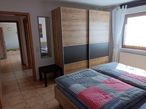 um quarto com uma cama, uma janela e um espelho em Fewo-Kuhn Bad Berleburg em Bad Berleburg