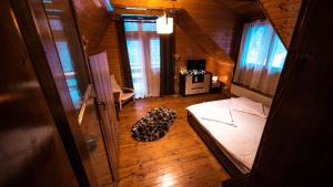 sypialnia z łóżkiem w drewnianym domu w obiekcie Pinewood Cabin w Braszowie