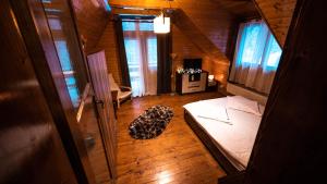 1 dormitorio con 1 cama en una casa de madera en Pinewood Cabin, en Brasov