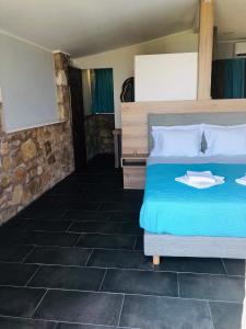 1 dormitorio con 1 cama grande con sábanas azules y almohadas blancas en Kimiro Drosia Zante, en Psarou