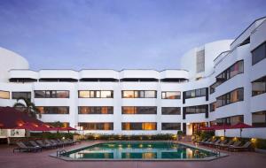 a hotel with a swimming pool in front of a building at Amari Don Muang Airport Bangkok in Bangkok