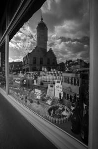 okno z widokiem na budynek z wieżą zegarową w obiekcie Bienvenue Chez Nous w mieście Bergues