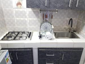 a kitchen with a stove and a sink at Charmant F3, 2 chambres + salon à Yoff plage bceao in Dakar