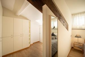 a bedroom with white cabinets and a bed and a mirror at Rooftop Delight with Terrace in Lucca