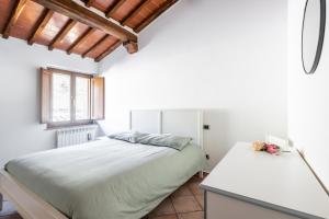 een witte slaapkamer met een bed en een bureau bij Siena Cozy Apartment with Private Garden! in Val di Pugna