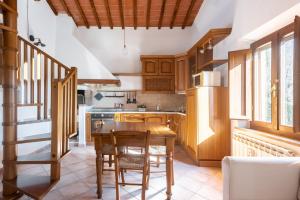 een keuken met houten kasten en een houten tafel bij Siena Cozy Apartment with Private Garden! in Val di Pugna