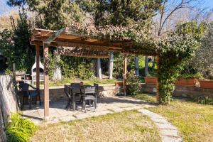 een pergola met een tafel en stoelen in een tuin bij Siena Cozy Apartment with Private Garden! in Val di Pugna