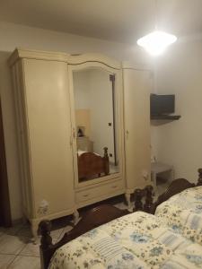 a bedroom with a cabinet with a dog in the mirror at Bed & breakfast Mezzaluna in Feletto