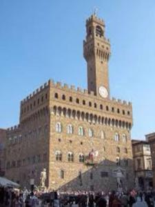 un gran edificio con una torre de reloj encima en Lorenzo Magnifico Typical Home Heart of Florence, en Florencia