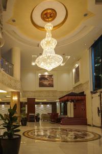 a lobby with two chandeliers in a building at Rose Oasis Hotel in Najran +59 photos