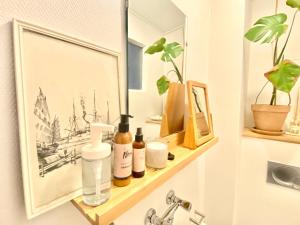 a bathroom shelf with bottles on it next to a sink at En hel lejlighed i midtbyen - centralt, hyggelig og tæt på alt! in Randers