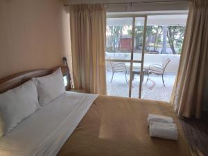 - une chambre avec un lit et une vue sur une terrasse dans l'établissement Calangute Residency, à Calangute