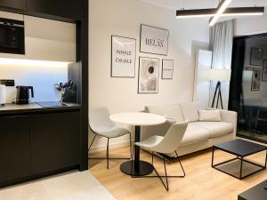 - un salon avec un canapé, une table et des chaises dans l'établissement O! Shellter Apartment PREMIUM by Oskar, à Rogowo