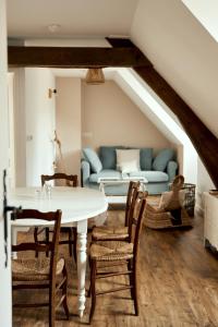 a dining room with a table and a couch at La Maison du Gasseau in Saint-Léonard-des-Bois