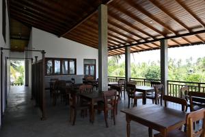 un restaurante con mesas y sillas y un balcón en Beach Inns Holiday Resort - Celeste, en Matara