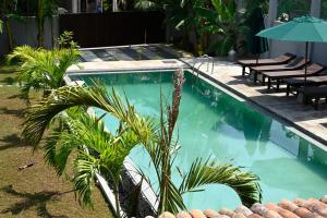 a swimming pool with palm trees in front of a house at Beach Inns Holiday Resort - Celeste in Matara