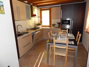 a kitchen with a table and some chairs in it at Monte Grappa Guest House in Romano D'Ezzelino