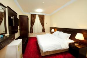 a hotel room with a bed and a television at Royal Almashaer in Makkah
