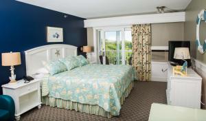 a hotel room with a bed and a window at Strawberry Hill Seaside Inn in Rockport