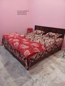 un letto con piumone rosso in camera di Hotel Supreme & Banquet a Sirhind