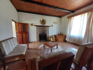 Lisbon Eco Lodge في غراسكوب: غرفة معيشة مع أريكة ومدفأة