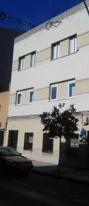 a white building with a tree in front of it at Hello Villarreal Suites in Villareal