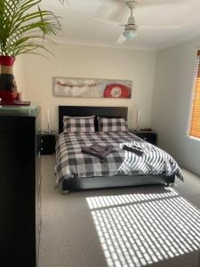 sypialnia z łóżkiem z czarno-białą kołdrą w obiekcie Our Townhouse in Toowoomba w mieście Toowoomba