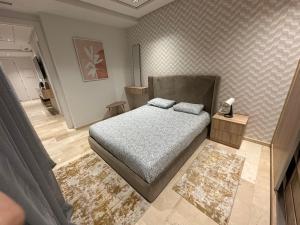 Un dormitorio pequeño con una cama y una alfombra. en Le LUXE EN BORD DE MER, en Tánger