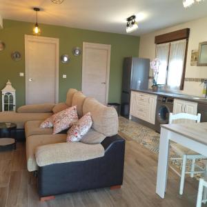 a living room with two couches and a kitchen at Apartamentos La casa del Zapatero in Corvera