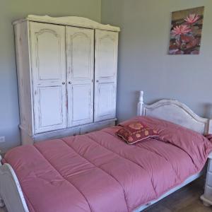 1 dormitorio con 1 cama rosa y armario blanco en Apartamentos La casa del Zapatero, en Corvera