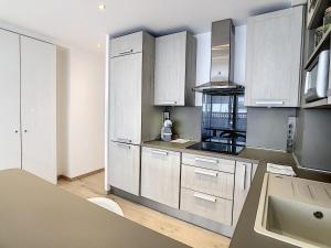 uma cozinha com armários brancos e um lavatório em Grand studio cabine à côté des plages NER634 em Cannes