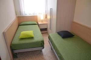 a small room with two beds and a window at Appartamenti Villa Frediana in Bibione