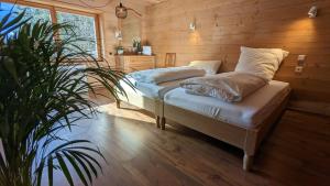 Un dormitorio con una cama con almohadas y una planta en Gemütliches Berg-Chalet mit Panoramablick en Bayrischzell
