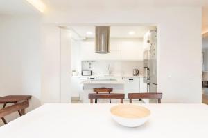 a white kitchen with a table and chairs at Cascais Center 3 bdr - Family Haven in Cascais