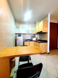 a kitchen with a wooden table and a refrigerator at [HERITAGE 3] HOMESTAY Studio 4Pax, FREE WIFI NETFLIX in Seri Kembangan