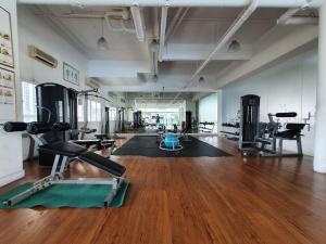 a gym with treadmills and exercise equipment on a wooden floor at [HERITAGE 3] HOMESTAY Studio 4Pax, FREE WIFI NETFLIX in Seri Kembangan