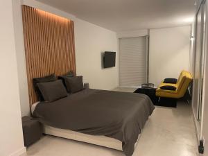 トレモリノスにあるTorremolinos centroのベッドルーム(大型ベッド1台、黄色い椅子付)
