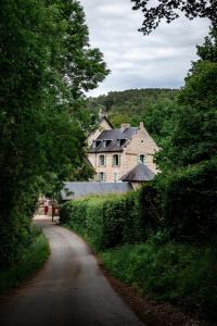 a road leading to a large house on a hill at La Maison du Gasseau in Saint-Léonard-des-Bois