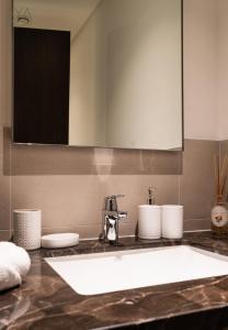 uma casa de banho com um lavatório e um espelho em AYA Boutique - Fancy One Bedroom Apartment in Downtown Dubai em Dubai