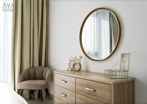 um quarto com um espelho e uma cadeira em AYA Boutique - Fancy One Bedroom Apartment in Downtown Dubai em Dubai