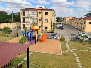 um parque infantil num parque ao lado de um edifício em LouieVille Studio Apartment em Lusaka