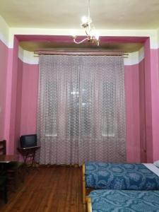 - une chambre avec un lit et un mur rose dans l'établissement Berlin Hotel, au Caire