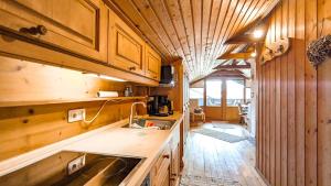 a kitchen with wooden cabinets and a sink in a room at Ferienapartment Edelsbergblick in Hopferau
