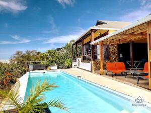 a villa with a swimming pool and a house at Les Balcons du sud - Villa Perle de l'Océan - 180 m2 avec piscine - Les Avirons in Les Avirons