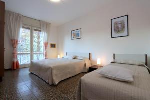 a bedroom with two beds and a window at Villa Stefano in Bibione